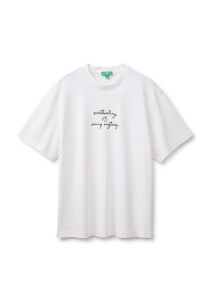 Biały t-shirt z krótkim rękawem z czarnym, odręcznym tekstem "overthinking VS doing anything" wyśrodkowanym z przodu.