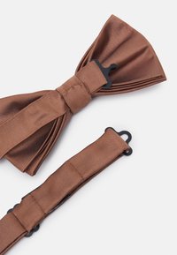 Nœud papillon en satin marron avec une finition texturée et une sangle ajustable dotée de quincaillerie noire pour le maintenir en place.