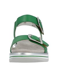 Grüne Ledersandale mit zwei verstellbaren Riemen und silbernen Schnallen. Sie verfügt über eine gepolsterte Innensohle und eine weiße Sohle mit einem grünen Akzentstreifen.