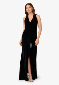 Czarna aksamitna wieczorowa suknia z głębokim dekoltem w serek, bez rękawów, z bocznym rozcięciem oraz dekoracyjnym, koralikowym akcentem w talii.