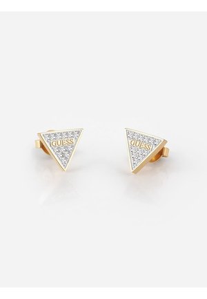 Goudkleurige driehoekige studs met heldere kristallen en het "GUESS"-logo in het midden op een witte achtergrond.