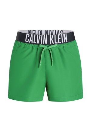 Grüne Badehose mit einem schwarzen elastischen Bund, der mit weißen "CALVIN KLEIN"-Logos bedruckt ist, Kordelzug und glatter Textur.