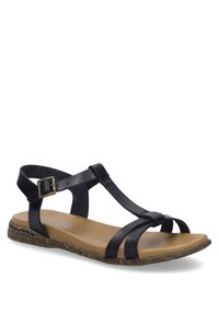Sandalo in pelle nera con cinturini incrociati, fibbia regolabile alla caviglia e soletta imbottita su una suola marrone texture.