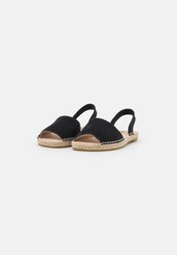 Svarta mocka slingback-skor med öppen tå, med en vävd jutesula och en slät läderinteriör.