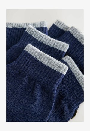 Sosete bleumarin cu mansete rib și gri deschis. Textură tricotată cu un finisaj neted. Patru perechi, fiecare având un design de mansetă contrastant.