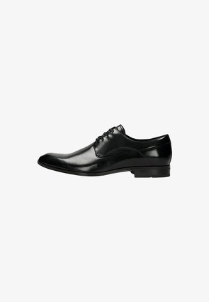 Scarpe eleganti in pelle nera con un design slanciato, punta affusolata e superficie liscia con cuciture minime. Suola piatta in gomma per una maggiore stabilità.
