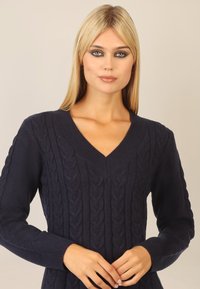 Dunkelblaues Kabelstrickpullover mit V-Ausschnitt, gerippten Bündchen und strukturiertem Muster. Hergestellt aus einem weichen, gemütlichen Stoff.