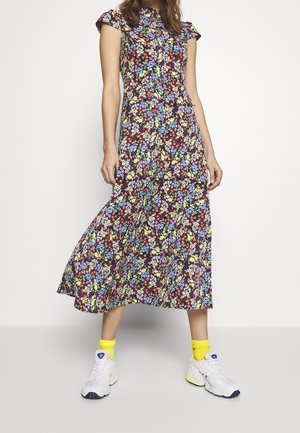 Floral midi dress with short ruffled sleeves, featuring a dark maroon base, assorted blue, yellow, and green flowers, paired with white sneakers and yellow socks.