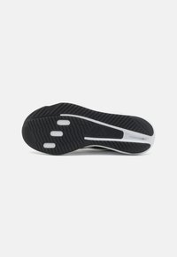 Black sneaker outsole with white accents, featuring a textured grip pattern and grooves. Includes three circular cushioning elements.
