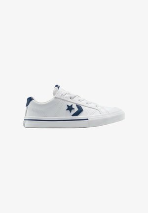 Baskets basses blanches avec étoile bleu marine et logo chevron, lacets blancs et semelle blanche texturée avec une bande bleu marine.