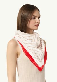 Seidenschal mit beigen und weißen Streifen, umrandet von einem roten Rand. Quadratische Form mit glatter Textur und einem im Eck aufgedruckten Logo.