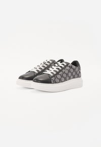 Sneaker in bianco e nero con motivo, con tomaia texturizzata, punta in pelle e suola spessa bianca, caratterizzate da lacci bianchi e design a profilo basso.