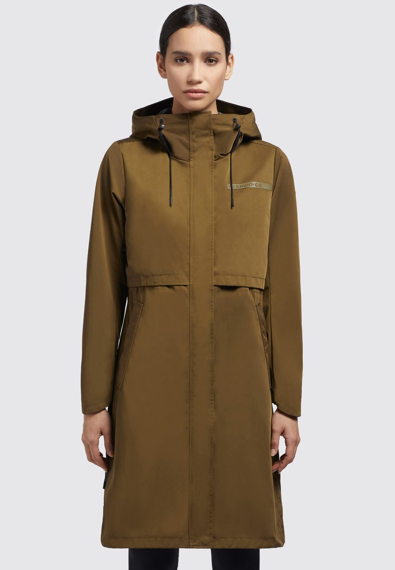 Giacca a vento marrone impermeabile con cappuccio, chiusura con zip frontale, tasche laterali, cordino regolabile e dettaglio del logo sul petto.