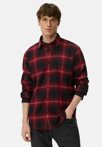 Rød og sort ternet flannel skjorte med knaplukning foran, lange ærmer og en brystlomme. Glat tekstur, afslappet design.