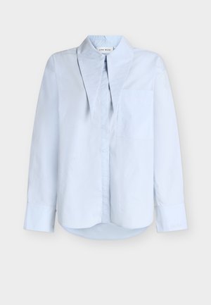 Jasnoniebieska koszula na guziki z kołnierzykiem mandaryńskim, pojedynczą kieszenią na piersi, długimi rękawami i lekko zaokrąglonym dołem. Gładka struktura tkaniny.