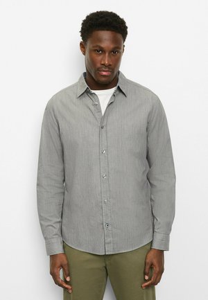 Graues gestreiftes Hemd mit Knöpfen, spitzem Kragen, durchgehender Knopfleiste und Manschetten. Getragen über einem weißen Unterhemd, kombiniert mit grüner Hose.