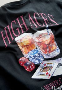 Dve kozarci viskija z ledom, poker žetoni, rdeče kocke in igralne karte pod napisom "HIGH ACES" na črni tkanini.