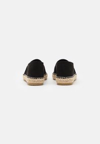 Sorte ruskinds espadriller med flad, vævet jute-sål og akcentueret syning. Simpelt design med rund tå og lav hæl.