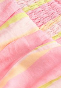 Soft fabric with pink, yellow, and light orange horizontal stripes and gathered elastic stitching detail.