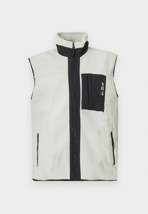 Hihaton fleece liivi, jossa on täysipitkä vetskari, musta rintatasku vasemmalla puolella ja mustat reunat vetskareissa sekä kauluksessa.