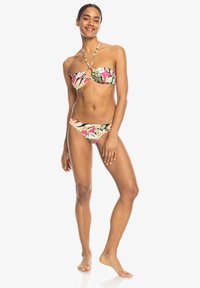 Bikini set featuring a bandeau top with floral pattern in pink and green, and matching low-rise bottoms. Made of smooth fabric.