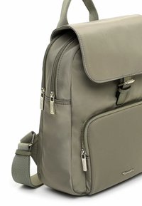 Roheline nailonist seljakott, millel on volditav klapp, kaks lukuga taskut ja reguleeritav õlarihm metallist detailidega.