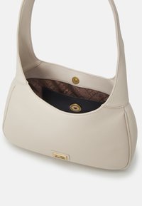 Beige läderaxelväska med guldknäppning, märkesinredning och en liten plack fram som står "Love Moschino."