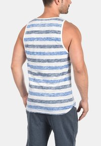 Hvit tanktopp med horisontale blå og grå striper. Laget av et mykt stoff, har den rund hals og en avslappet passform.