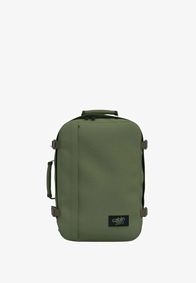 Vihreä kangaskassi suorakulmaisen muodon kanssa, kylkiläisillä kahvoilla, säädettävillä hihnoilla ja logopatchilla. Rakenteellinen materiaali vetoketjuilla.