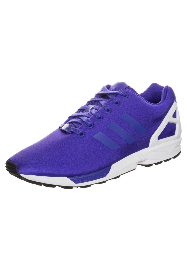 Scarpa sportiva viola con tomaia in tessuto, tre strisce tonali, suola bianca e suola esterna nera per la trazione. Presenta un dettaglio del tallone a contrasto.