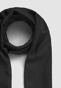 Czarny szalik wykonany z miękkiego, strukturalnego materiału. Posiada wzór w jodełkę i jest ułożony w kształcie okręgu.