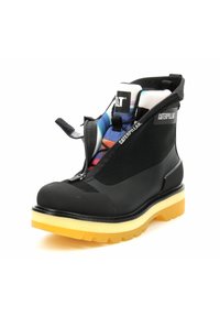 Bottines noires à la cheville avec une tige en maille texturée, fermeture éclair et semelle en caoutchouc jaune. Présente le logo Caterpillar sur un panneau latéral.