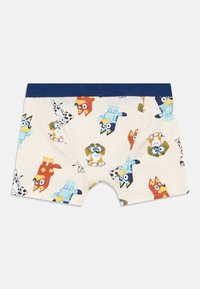 Dječji donji veš s svijetložutom podlogom i šarenim uzorcima crtanih pasmina. Elastična traka u tamnoplavoj boji, materijal od mekane pamuka i bez istaknutih tekstura.