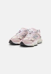 Pink and cream sneakers with a mesh and suede upper, featuring a chunky white midsole and grey accents. Reflective details on the sides.