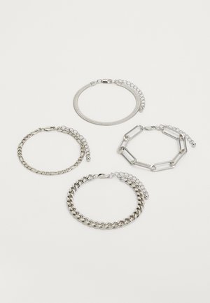 Fire sølvarmbånd arrangert på en hvit bakgrunn: en slangekjede, et tynt lenkekjede, et kraftig lenkekjede og et papirklipp-design.