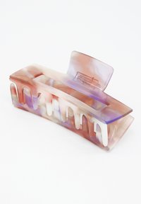 Genomskinlig akryl hårklämma i pastellnyanser av rosa, lila och vitt. Har en vågig design med utskärningar och ett säkert gångjärn.