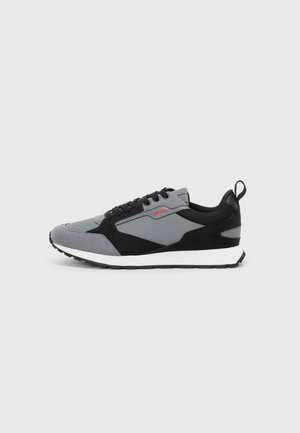 Grey and black athletic sneaker with a mesh and suede upper, white midsole, black rubber outsole, and a red logo accent.