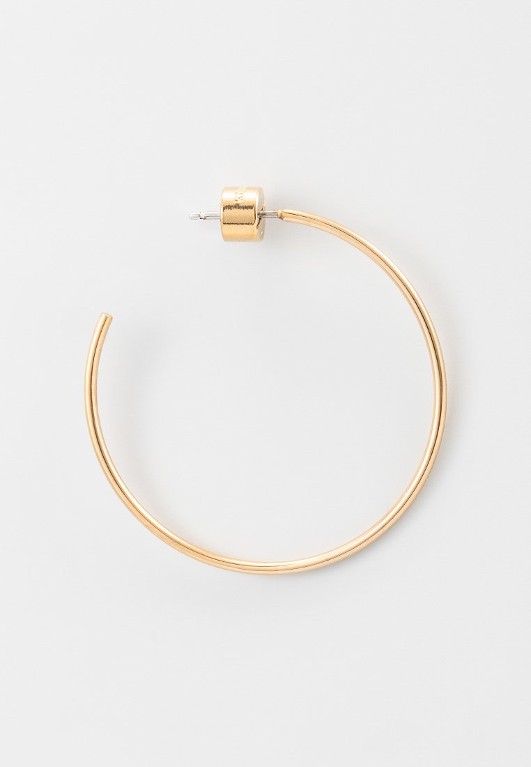 Goldfarbene Creolen mit einem schlanken, kreisförmigen Design. Sie verfügen über einen strukturierten zylindrischen Verschluss und eine glatte, polierte Oberfläche.