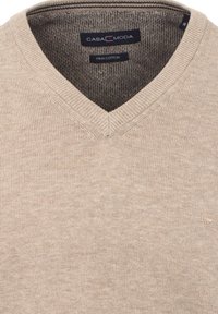 Beiger V-Ausschnitt-Pullover aus Pima-Baumwolle mit strukturiertem Strickmuster. Mit ribbeltem Kragen und dezentem Logo an der Unterseite.