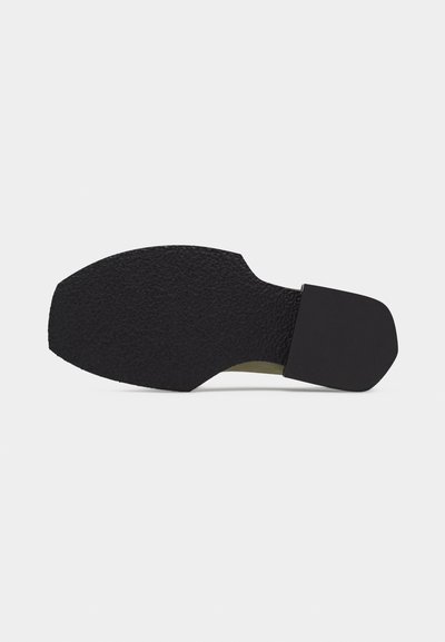 Σόλα μαύρου παπουτσιού με υφή για πρόσφυση στο εμπρόσθιο μέρος και λείο, τετράγωνο τακούνι, σε ανοιχτό γκρι φόντο.