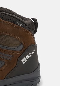 Stivale da escursionismo in camoscio marrone e sintetico grigio scuro con rivestimento in tessuto, suola antiscivolo e dettagli del logo sul lato esterno. Design leggero.
