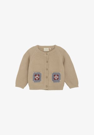 Beige stickad kofta med rund halsringning, knappstängning och två broderade patchfickor i blå och röda blommönster.
