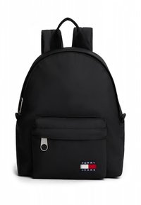 Melns neilona mugursoma ar apaļu dizainu, priekšpusē rāvējslēdzēja kabata un apakšā zīmola uzlīme. Iekļautas polsterētas plecu siksnas.