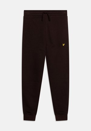 Pantalones de treino pretos com cordão na cintura, punhos canelados e um pequeno logótipo amarelo na coxa esquerda. Feitos de tecido suave, com um corte de perna reta.