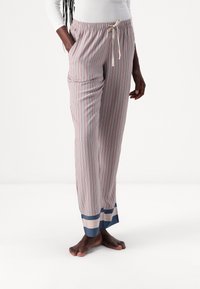 Gestreepte pyjamabroek met verticale lijnen in rood, blauw en wit, elastische tailleband, touwtjestrekker en contrasterende blauwe zoom.