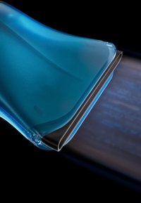 Transparenter blauer und schwarzer Abzieher entfernt Wasser von einer dunklen Oberfläche mit sichtbaren Streifen, vor schwarzem Hintergrund.