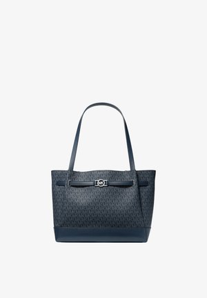Granatowa torba typu tote Michael Kors z monogramem MK, skórzaną podstawą, dwoma paskami na ramię oraz srebrną klamrą z logo MK z przodu.
