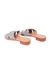 Sandali scivoli argentati con glitter, caratterizzati da un design a fascia incrociata, una soletta imbottita color marrone chiaro e un tacco basso e impilato.