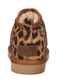 Achteraanzicht van een bruin en zwart luipaardprint slof met een bonten voering en een trekband, gelabeld "Wombat Australia" op de hiel.