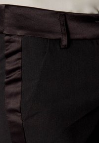 Black trousers with a matte finish and satin accents along the side seams; features a classic waistband and flat front design.